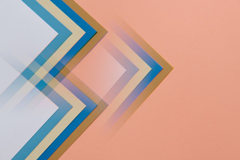 Abstract design featuring overlapping geometric shapes in soft pastel colors on a peach background.